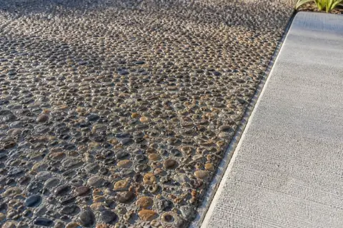 Exposed aggregate concrete surface showing river gravel locked in gray paste