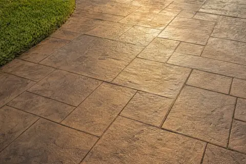 Stamped concrete driveway in an ashlar slate pattern with warm color accents